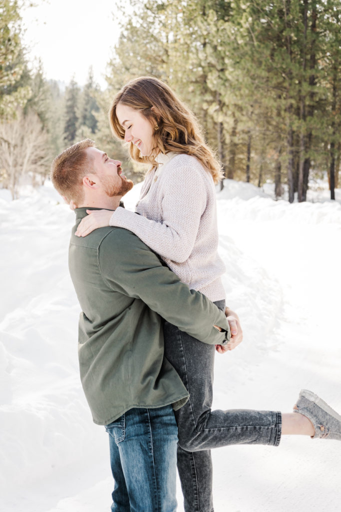 Couples posing in forest with guy carrying girl for couples winter photography. 