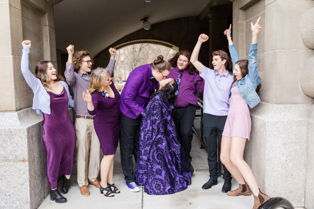 Boise, Idaho capitol building for wedding photography. Bride and groom kiss, wedding party cheering. 